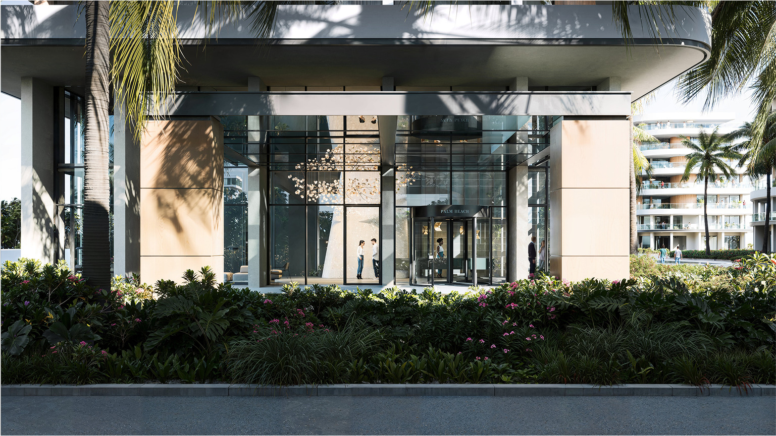 Palm Beach building entrance with revolving doors and lush landscaping.