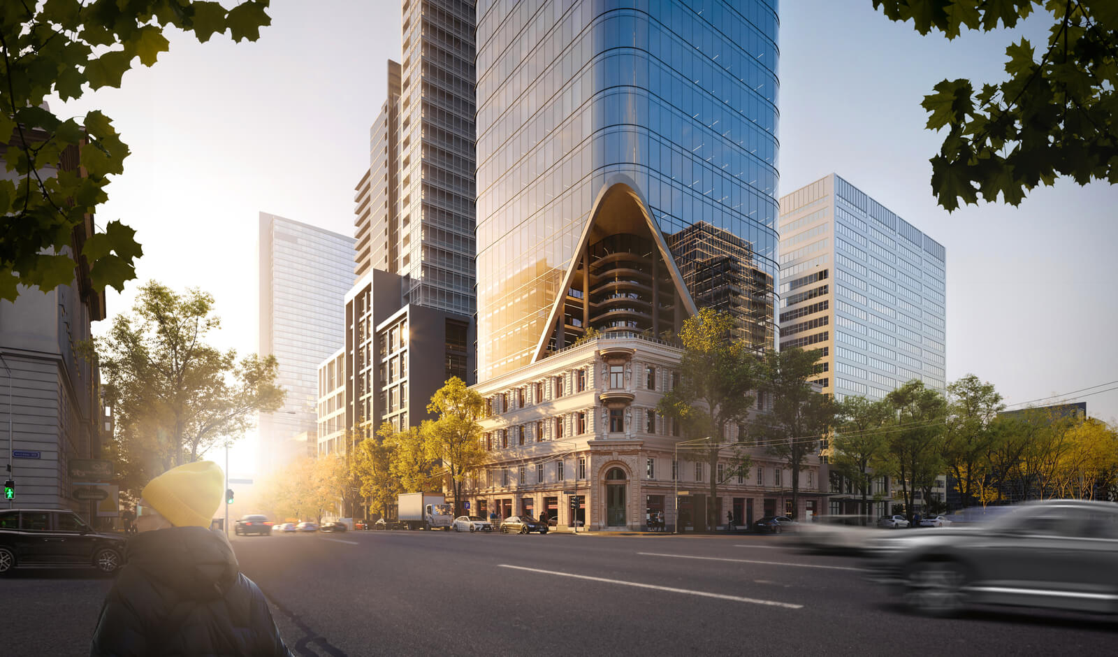 Modern skyscraper and historic building on a city street at sunrise.