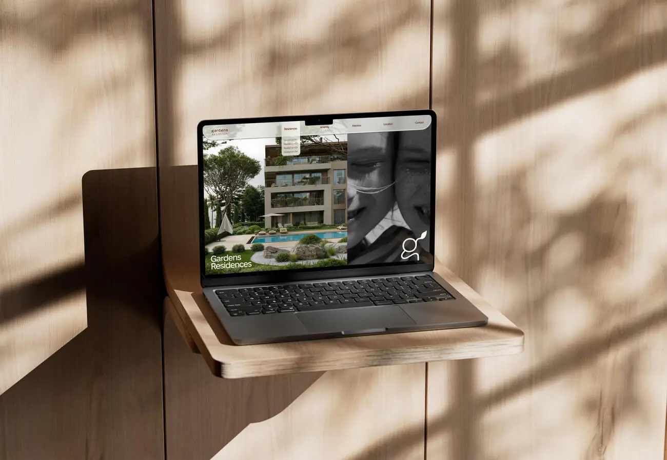 Laptop displaying Gardens Residences website, showcasing luxury apartments and pool.